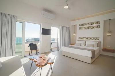 a bedroom with a bed and a view of the ocean at Sfakia Seaside luxury Suites in Khóra Sfakíon
