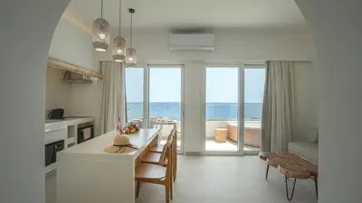 a kitchen with a table and chairs and a view of the ocean at Sfakia Seaside luxury Suites in Khóra Sfakíon