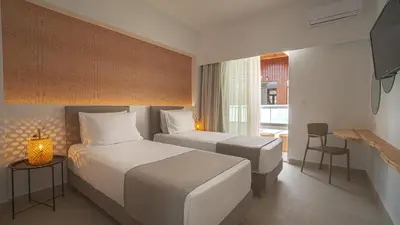 a hotel room with two beds and a television at Sfakia Seaside luxury Suites in Khóra Sfakíon