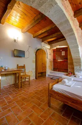 a bedroom with a bed and a table in a room at STAMATOGIANNIS Traditional Apartments in Kalivianí