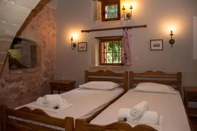 a bedroom with two beds with towels on them at STAMATOGIANNIS Traditional Apartments in Kalivianí