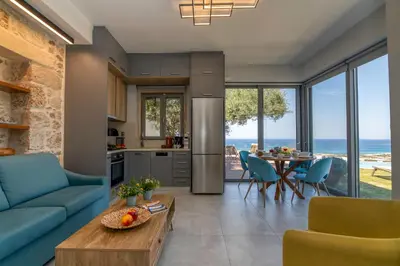 a kitchen and living room with a blue couch and a table at Villa Maritini in Chania Town