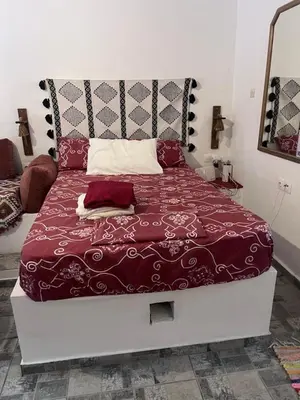 a bedroom with a large bed with a red comforter at Vryses Crete-Village Vibes in Vryses