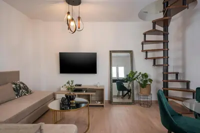 a living room with a couch and a tv on a wall at Ethyr City Living in Chania Town