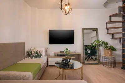 a living room with a couch and a flat screen tv at Ethyr City Living in Chania Town