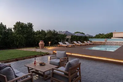 a patio with chairs and a table next to a pool at Villa Enny, 3 BD with Private Heated Pool in Ayiá