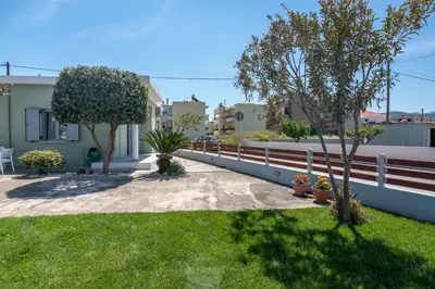 a house with a fence and some trees and grass at Lahardi - Seaside House in Kissamos