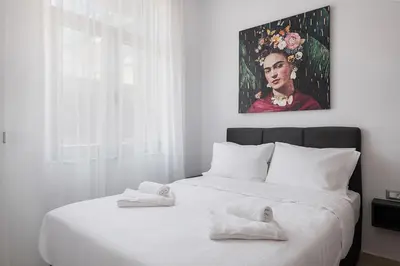 a bedroom with a white bed with a painting on the wall at Kappa Residence in Chania Town