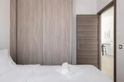 a bedroom with a white bed and a wooden wall at Kappa Residence in Chania Town
