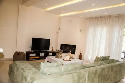 a living room with a couch and a tv at ΠΑΡΑΘΑΛΑΣΣΙΟ in Ayiá