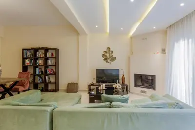 a living room with two couches and a tv at ΠΑΡΑΘΑΛΑΣΣΙΟ in Ayiá