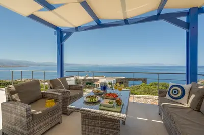 a patio with couches and a table with food on it at Villa Hemera ocean view private heated pool in Chorafakia