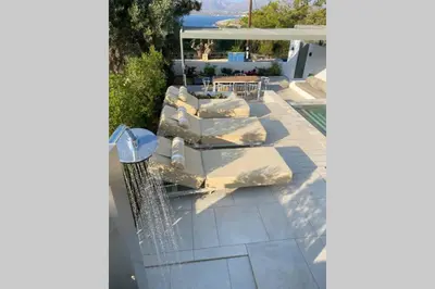 a patio with pillows and a table and a fence at SeaView villa with piano by Chania Living Stories in Chania Town
