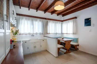 a kitchen with white cabinets and a wooden ceiling at SeaView villa with piano by Chania Living Stories in Chania Town