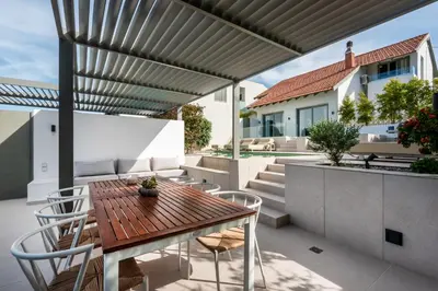 an outdoor patio with a wooden table and chairs at SeaView villa with piano by Chania Living Stories in Chania Town