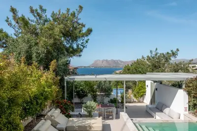 a villa with a swimming pool and a patio with an umbrella at SeaView villa with piano by Chania Living Stories in Chania Town