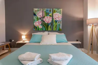 a bedroom with a blue bed with towels on it at Chania dream apartment in Chania Town