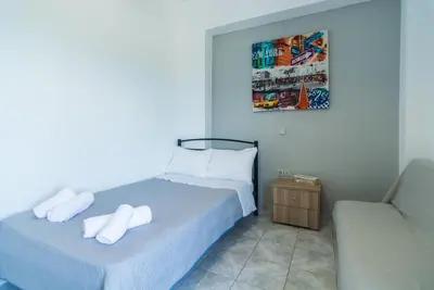 a bedroom with a bed and a chair with towels at Anastasia Home in Palaiochóra