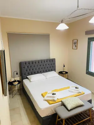 a bedroom with a large bed and two chairs at Casa Mersini in Chania Town