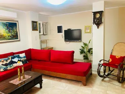 a living room with a red couch and a tv at Casa Mersini in Chania Town