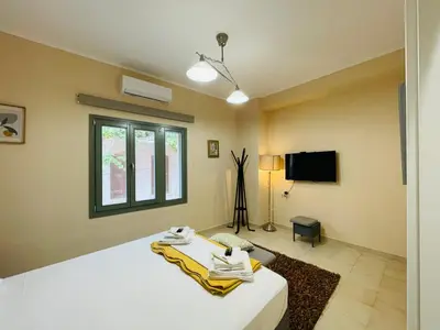 a bedroom with a white bed and a tv at Casa Mersini in Chania Town