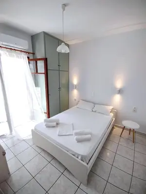 a bedroom with a white bed with towels on it at Captain Michalis Apartments - 750m from Kalamaki Beach in Galatás
