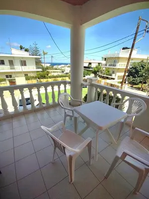 a patio with a table and chairs on a balcony at Captain Michalis Apartments - 750m from Kalamaki Beach in Galatás