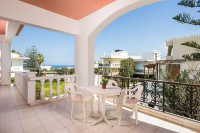 a balcony with a table and chairs on it at Captain Michalis Apartments - 750m from Kalamaki Beach in Galatás
