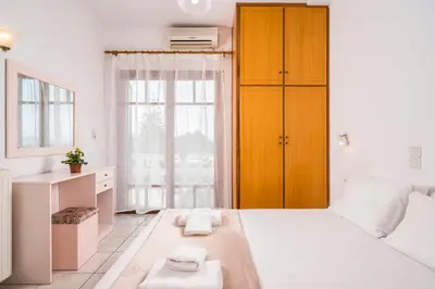 a bedroom with a large bed with two towels on it at Captain Michalis Apartments - 750m from Kalamaki Beach in Galatás