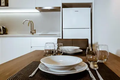a wooden table with plates and glasses on it at ANTEL Suites & Apartments in Chania Town