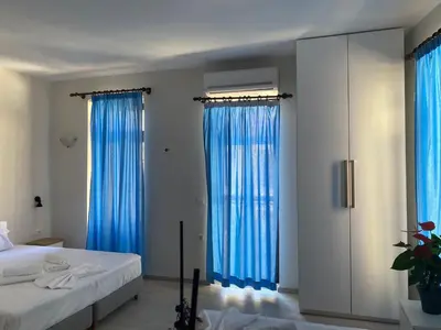 a bedroom with two beds and blue curtains at Casa Argo in Chania Town