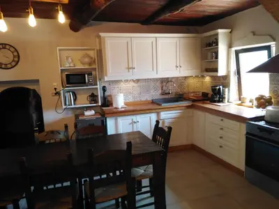 a kitchen with white cabinets and a wooden table at Villa Terpsi in Ravdhoúkha