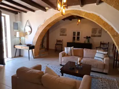 a living room with two couches and an archway at Villa Terpsi in Ravdhoúkha