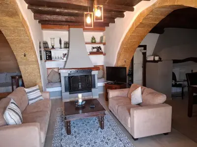 a living room with two couches and a fireplace at Villa Terpsi in Ravdhoúkha