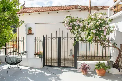 a gate to a white house with flowers on it at Casa Elafonisi N2-10min from the beach in Plokamianá