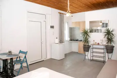 a white kitchen with a table and chairs and a counter at Casa Elafonisi N2-10min from the beach in Plokamianá