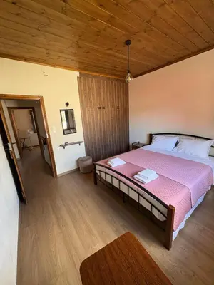 a bedroom with a large bed with a pink blanket at Nikos Traditional House in Maláthiros