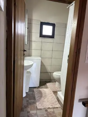 a bathroom with a toilet and a sink and a window at Nikos Traditional House in Maláthiros