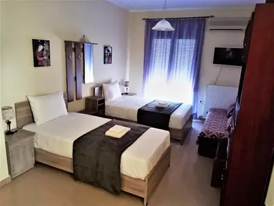 a hotel room with two beds and a television at Alkioni City Apartments in Chania Town