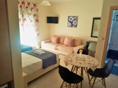 a bedroom with a bed and a couch and a table at Alkioni City Apartments in Chania Town