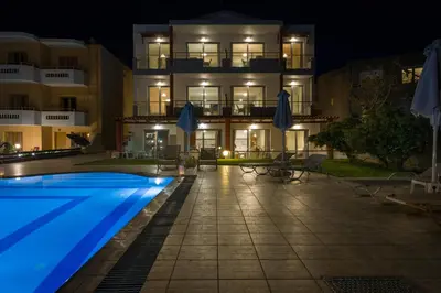a hotel with a swimming pool at night at Giannarakis Beach in Stalos