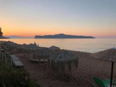 a beach with many straw umbrellas and the ocean at Kato Stalos Mare in Stalos