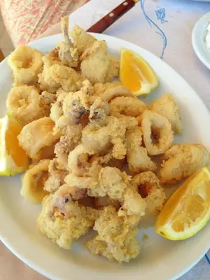 a plate of shrimp with orange slices on a table at Kato Stalos Mare in Stalos
