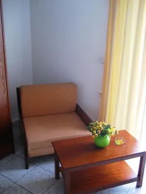 a chair and a table with a vase of flowers at Ouranos Studios in Kalamaki Chanion