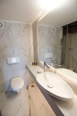 a white bathroom with a sink and a toilet at Casa di Goya in Chania Town