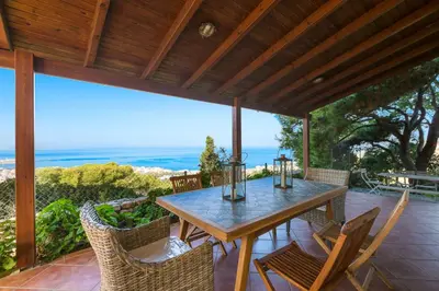 a table and chairs on a patio with a view of the ocean at Casa di Goya in Chania Town