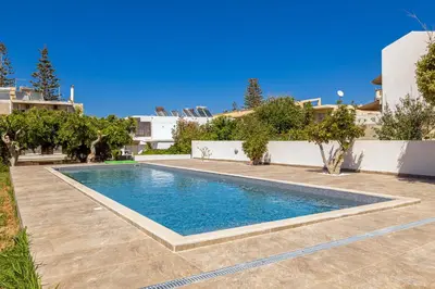 a swimming pool in the backyard of a house at CHRISTINE SEASIDE APARTMENTS IN CHANIA in Stalos
