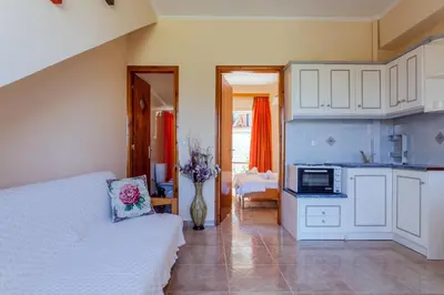 a bedroom with a bed and a kitchen at CHRISTINE SEASIDE APARTMENTS IN CHANIA in Stalos