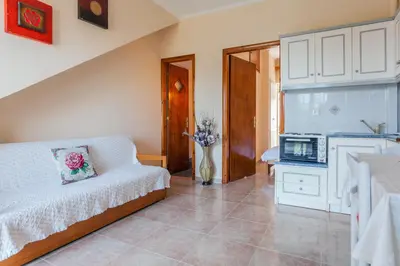 a bedroom with a bed and a vase of flowers at CHRISTINE SEASIDE APARTMENTS IN CHANIA in Stalos