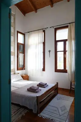 a bedroom with two beds and two windows at Lindas Convent Garden Home 4 in Chania Town
